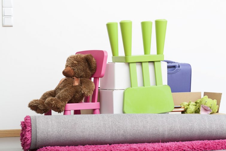 Familie beim Umziehen mit Kindern – Eltern und Kinder mit Umzugskartons