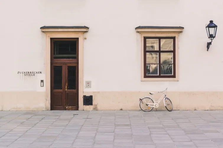 Entdecken Sie die charmanten Straßen von Wien mit dieser ansprechenden Aufnahme: Ein idyllisches Bild einer ruhigen Gasse, die „Zuckerbäcker Stiege“, mit einer eleganten alten Tür und einem klassischen Fenster
