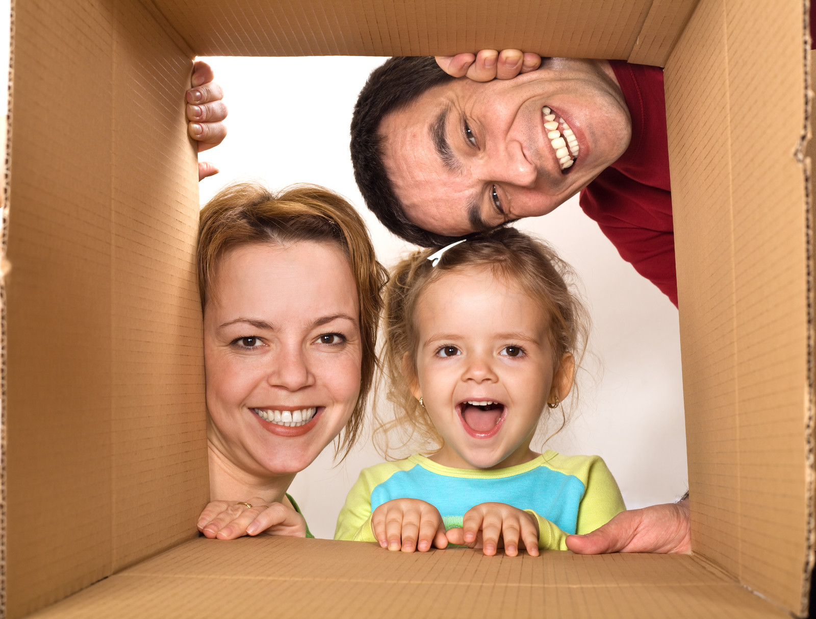 Familie schaut durch einen Umzugskarton
