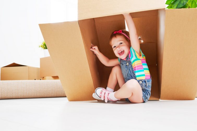 Kinder spielen mit Umzugskartons – positive Einstellung beim Umziehen mit Kindern