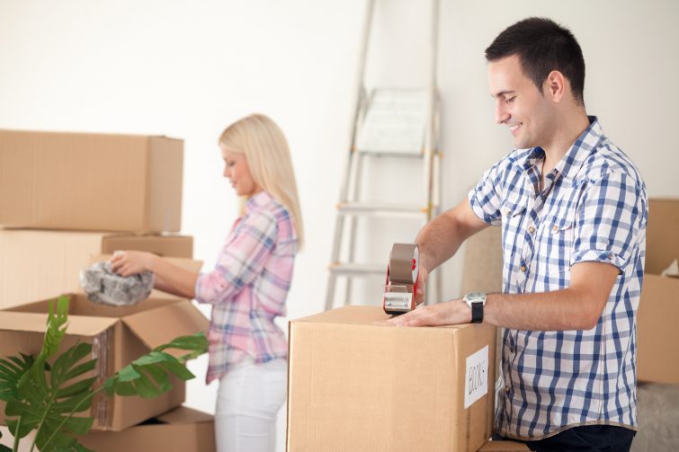 Umzugskartons packen _ young couple packing moving boxes, ready for move out