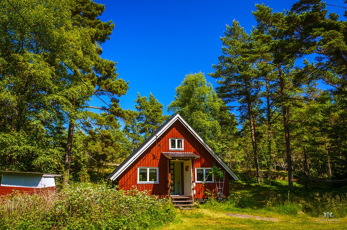 Charmantes rotes Holzhaus in Schweden, umgeben von dichten Wäldern – ein perfekter Rückzugsort nach Ihrem Umzug nach Schweden. Ideal für Ruhe und Privatsphäre in der Natur.
